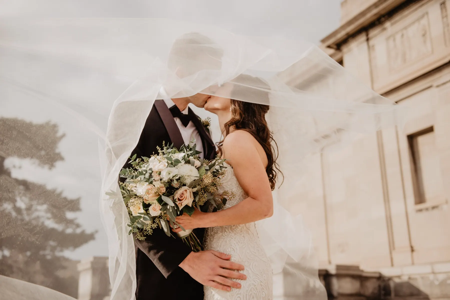 Newlyweds kissing outside their venue