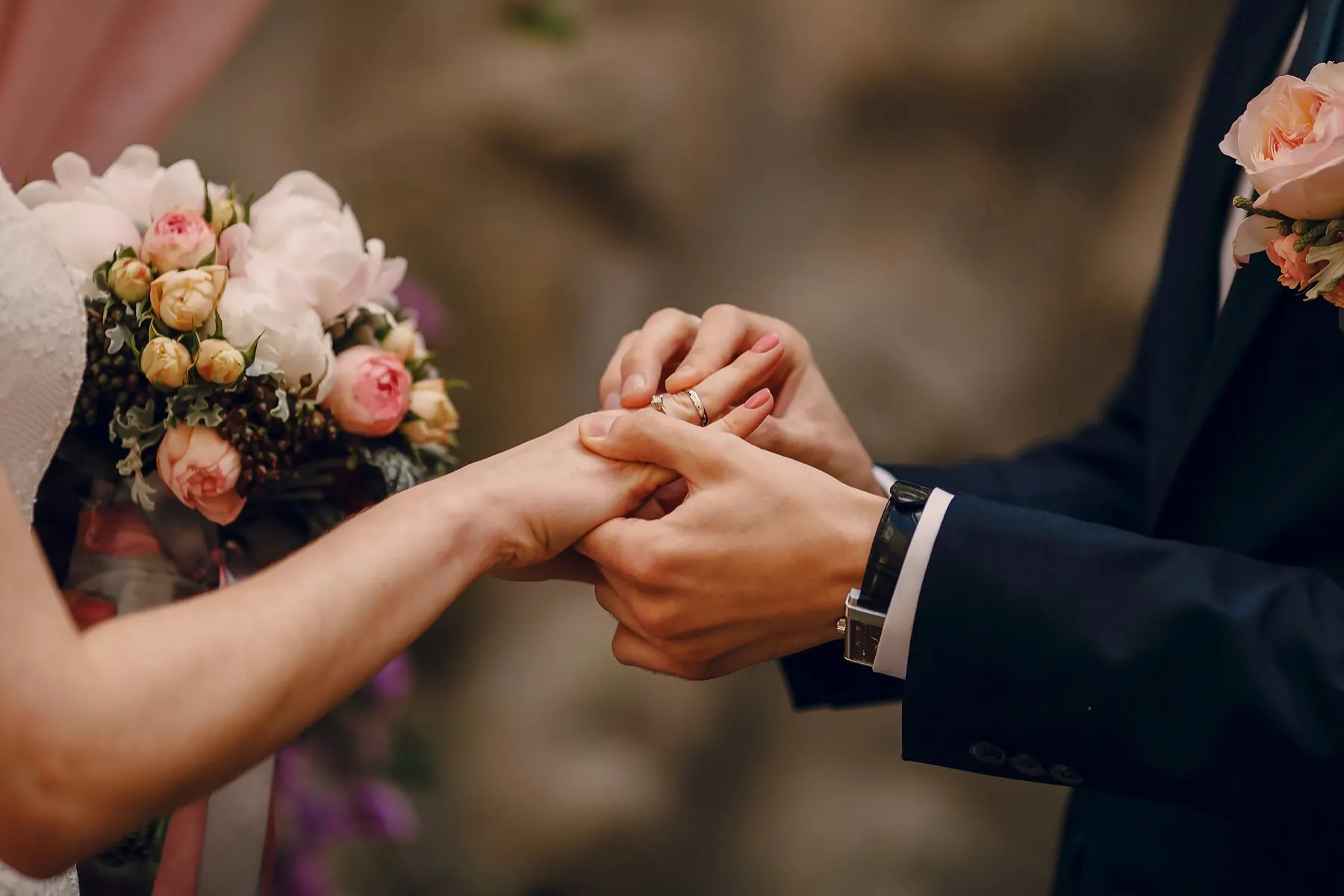 Bride showing her wedding ring among flowers