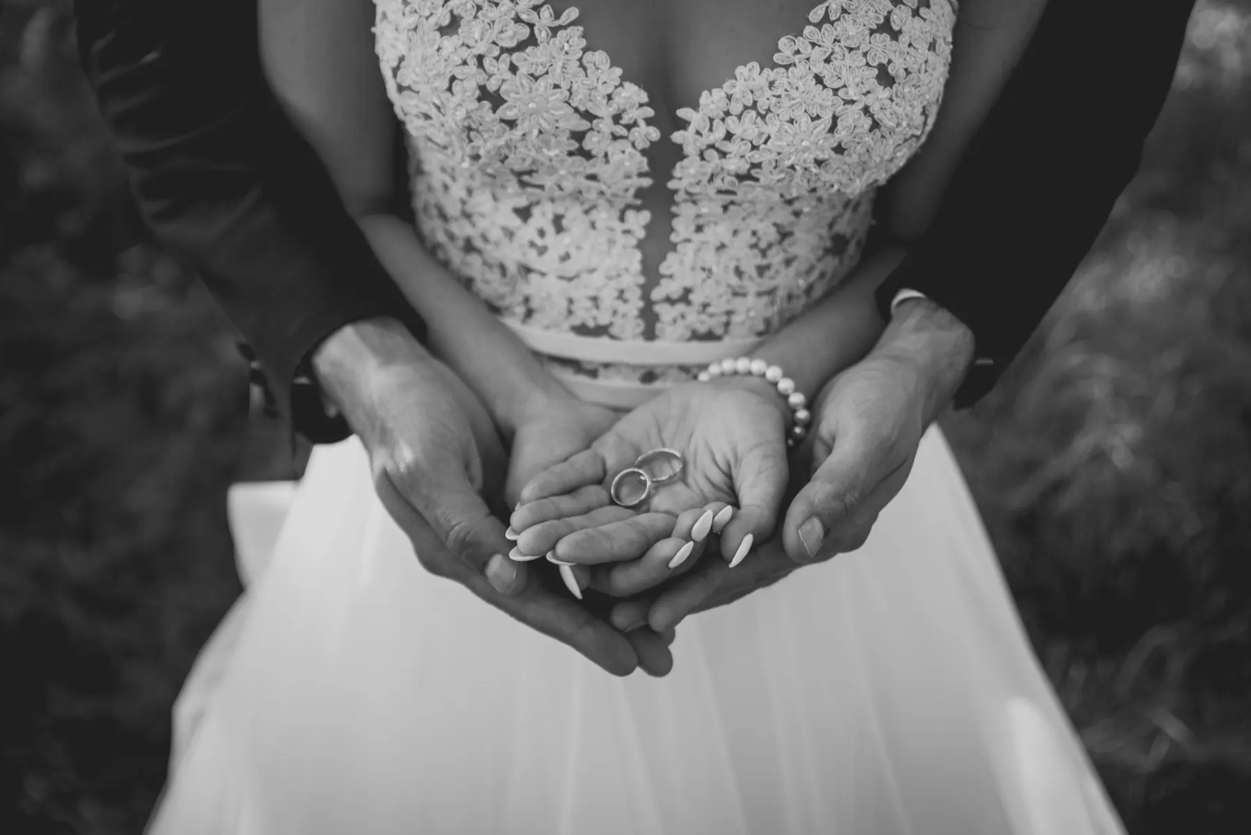 Wedding rings resting in the couple’s hands
